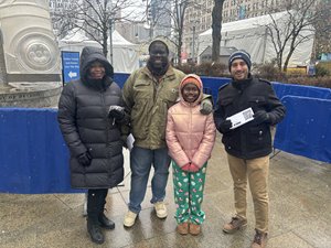 Community Crew member giving out a voucher for free ice skating at Campus Martius. 