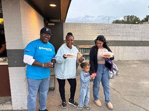Michigan First Community Crew handing out free food vouchers at a local sports game. 